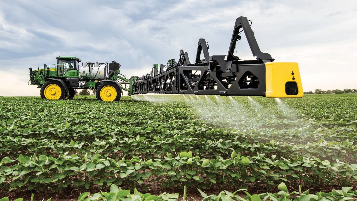 Lähikuva John Deere -ruiskutuspuomista aavalla pellolla.