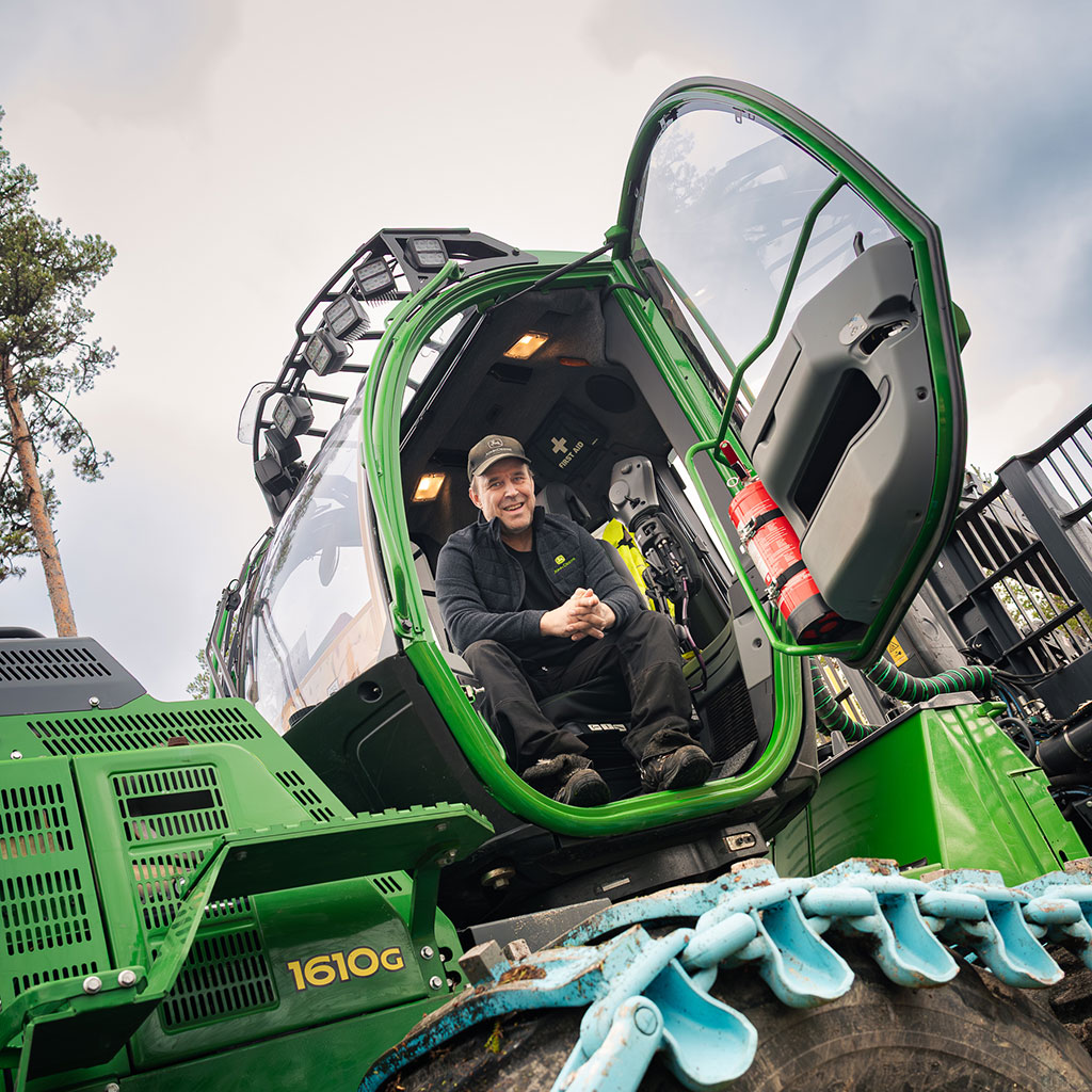 Hymyilevä kuljettaja 1610G-kuormatraktorissa