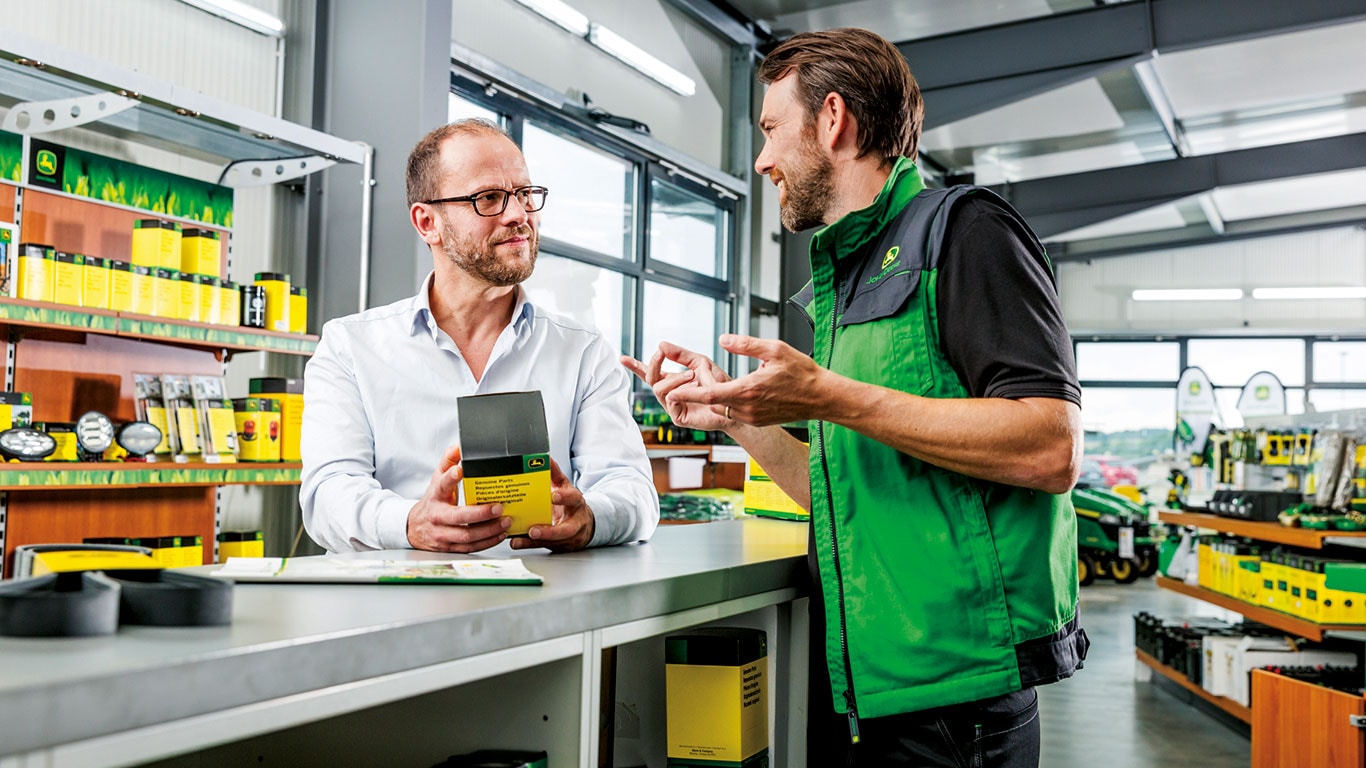 John Deere -varaosamyyjä ja asiakas varaosamyymälässä