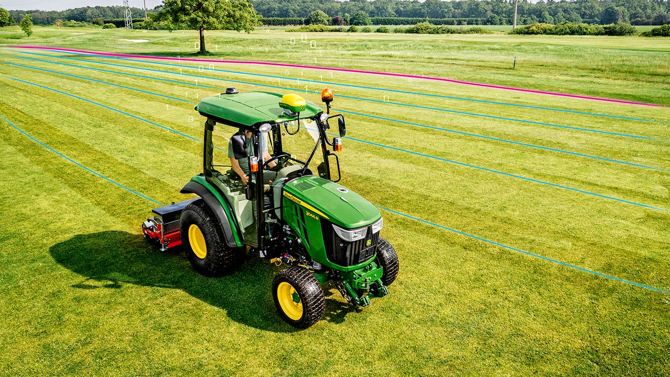 Golfkentänhoitaja työskentelee nurmialueella John Deere -kiinteistötraktorilla.