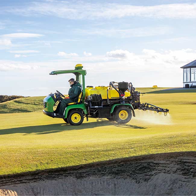 Golfkentänhoitaja työskentelee nurmialueella John Deere -ruiskutuslaitteella
