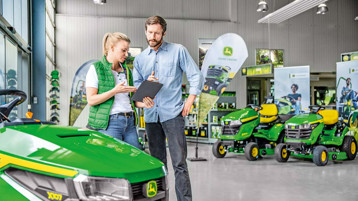 John Deere -jälleenmyyjä neuvoo asiakasta John Deere -leikkurin ostossa.