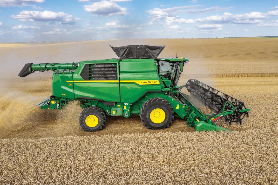 Sivukuva John Deere -leikkuupuimurista, jonka leikkuupöytä korjaa vehnää suurella pellolla