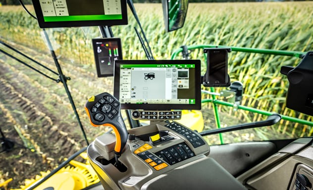Itsekulkeva ajosilppuri F9 700 kuormaamassa 6R John Deere -traktorin vetämää Joskin-perävaunua