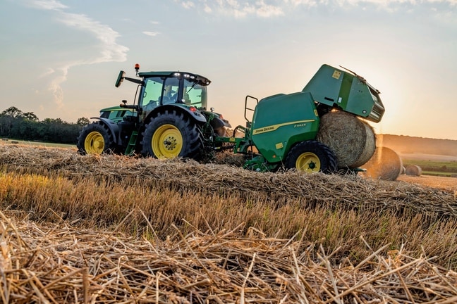 John Deere 6M -traktorin vetämä John Deere F442M -paalain työntää ulos olkipaalin