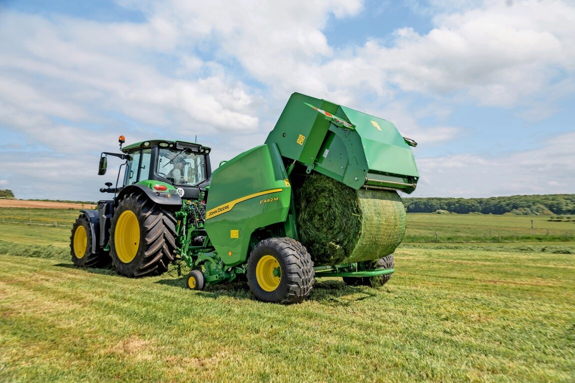 John Deere 6M -traktorin vetämä John Deere F442M -paalain työntää ulos heinäpaalin